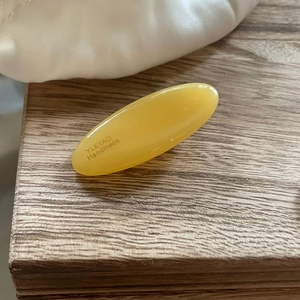 Minimalist yellow oval resin hair clip with YLETAO Handmade engraving on a wooden surface