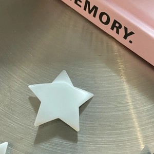 Pink matte pentagram star hair clip on a silver tray with a stylish girlish aesthetic