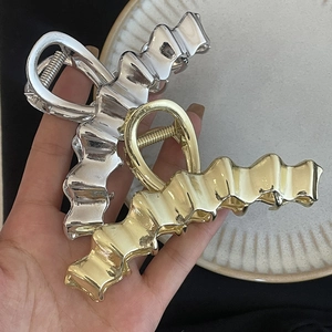 Elegant wavy metal hair claw clips in polished silver and gold finishes for women