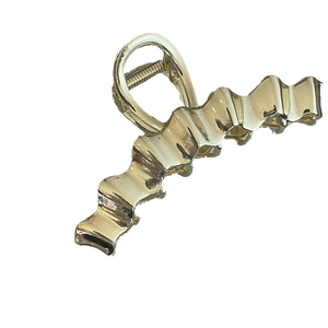 Minimalist light gold wavy metal claw clip for women with a sleek mirror finish