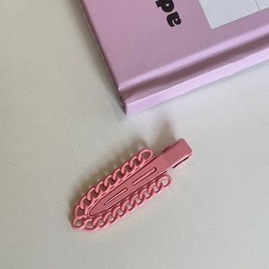 Detailed view of candy pink metal chain link hair clip with matte lacquer finish