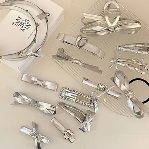 Set di fermagli per capelli argentati con fiocco, cuore e strass su un vassoio