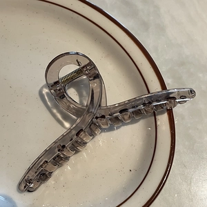 Gros plan sur la grande pince à cheveux de 14 cm en acrylique café avec ressort doré