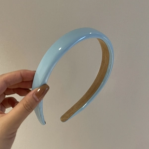 Detailansicht eines hellblauen glänzenden Stirnbands mit rutschfestem Samtfutter