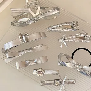 Dettaglio del set di fermagli per capelli in metallo argento e elastico con strass
