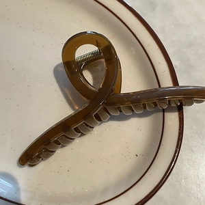 Gros plan d'une pince à cheveux de 14 cm en acrylique ambré avec design torsadé croisé