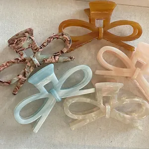 Elegant acetate bow hair claws in tortoiseshell and pearlescent finishes for women