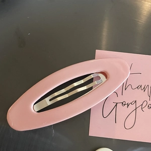Pince à cheveux ovale ajourée rose pour filles avec une finition brillante sur fond sombre