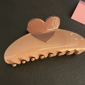 Glossy caramel hair claw clip with heart detail for thick hair on black texture background