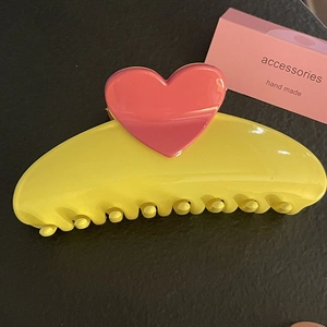 Detailed top view of large yellow hair claw clip with 3D red heart decoration