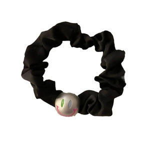 Elastic black satin scrunchie featuring a polished silver smiley face charm decoration