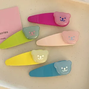 Cinq barrettes à cheveux ours en résine macaron présentées dans un plat en céramique