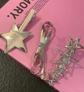 Gros plan d'un ensemble de barrettes étoile en métal argenté pour femme sur un livre