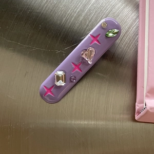 Detailed top view of purple candy color hair clip with star motifs and multi-shape rhinestones