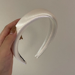 Detailed view of the anti-slip black inner strip on a premium white satin padded headband