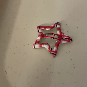 Close-up of Y2K star hair clip featuring a red and white checkered pattern on metal surface