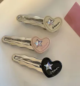 Lot de trois barrettes argentées ondulées avec breloques en forme de cœur crème, rose et noir