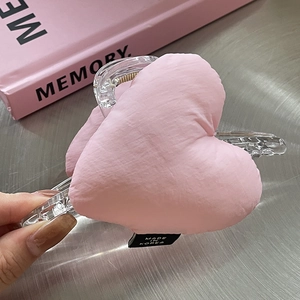Pince à cheveux coréenne en acrylique avec un cœur rose en peluche, vue en main
