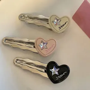Trois pinces à cheveux en métal ondulé avec cœurs en résine rose et noir et strass étoilé
