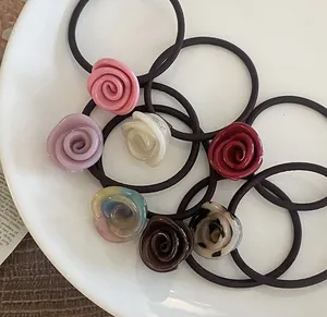 Flat lay of colorful resin rose hair scrunchies displayed on a white ceramic plate