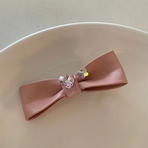 Barrette nœud en similicuir rose avec cristal de cœur et détail papillon élégant