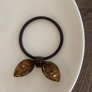 Élastique à cheveux élégant avec nœud en acrylique à motif écaille sur plat blanc