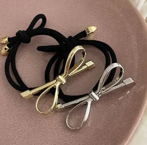 Detailed close-up of metallic bow elastic hair ties in gold and silver finishes
