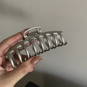 Détails d'une grande pince à cheveux en métal argent mat avec ressort pour coiffures en chignon