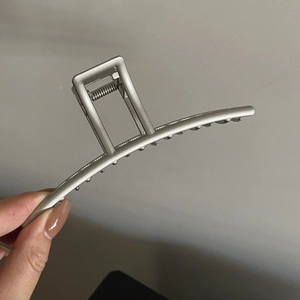 Détail d'une grande pince à cheveux en métal argent mat avec ressort robuste
