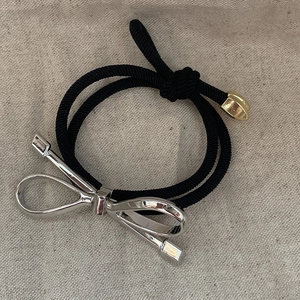 Elastic double-strand black hair tie with polished silver bow and gold metal bead detail