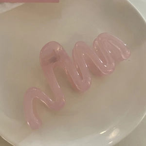 Pince à cheveux ondulée rose grand format en résine sur plateau en céramique