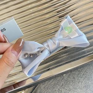 Handmade light blue satin bow hair clip with rhinestone and green heart detail