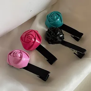 Gros plan de quatre pinces à cheveux rose brillant en bleu, noir, rose et rouge rose