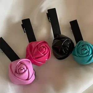 Lot de quatre barrettes à cheveux roses en cuir brillant rose, noir et bleu