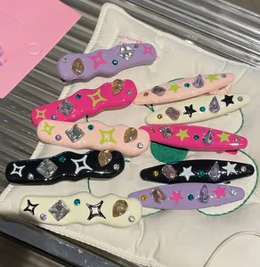 Detailed macro view of Y2K star hair clips featuring rhinestones and colorful spray paint