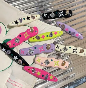 Detail of colorful Y2K rhinestone hair clips with star patterns on textured background