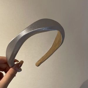 Padded silver satin headband with wide wave design and non-slip velvet lining