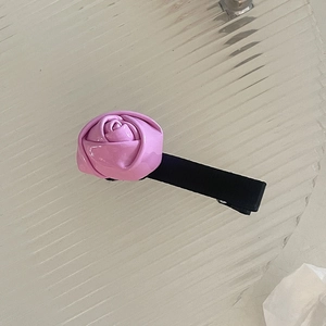 Vue détaillée de la pince à cheveux rose en cuir avec un clip bec de canard en tissu noir