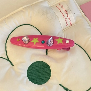 Detailed macro view of a peach pink Y2K hair clip with neon stars and colorful rhinestones