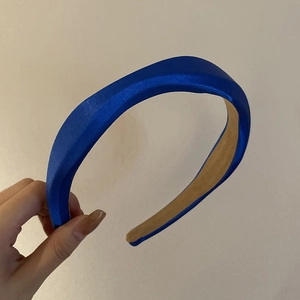 Detail view of glossy wave satin headband in bright blue with thick padded design