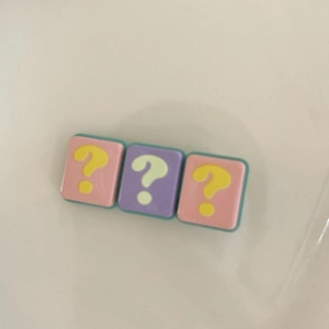 Close-up of cute resin hair clips featuring question marks in pink and purple colors