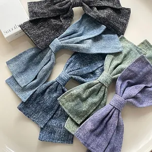 Oversized washed denim bow hair clips in five colors including blue, black and purple