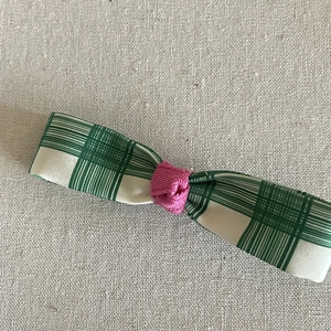 Détail de la pince à cheveux noeud vichy vert avec noeud en soie rose sur lin