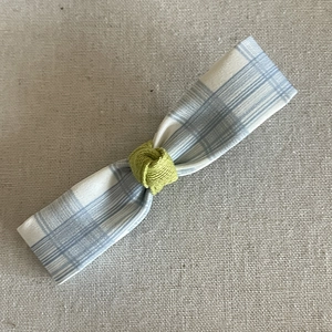 Détail de la pince à cheveux nœud vichy bleu et blanc avec nœud tricoté vert