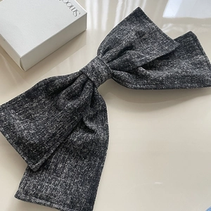 Oversized dark gray denim bow hair clip with textured fabric for women in minimalist style