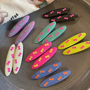 Colorful oval duckbill hair clips with mini bow patterns in seven vibrant candy colors