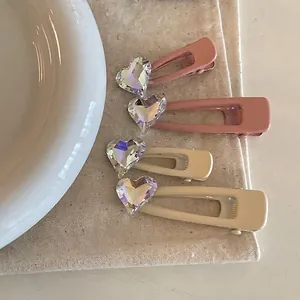 Set de 4 horquillas de corazón con diamantes en rosa y beige sobre un plato de cerámica