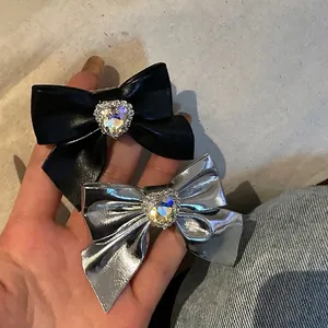 Fermagli per capelli con fiocchi in ecopelle lucida e strass a cuore neri e argentati