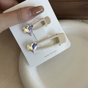 Detalle de las horquillas de corazón crema con diamantes de imitación y clip de pico de pato
