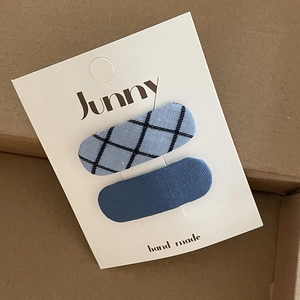 Detail of blue plaid and solid fabric oval hair clips on handmade display card
